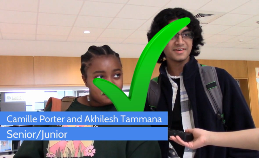 Two students stand answering a question. A green checkmark is over their faces.