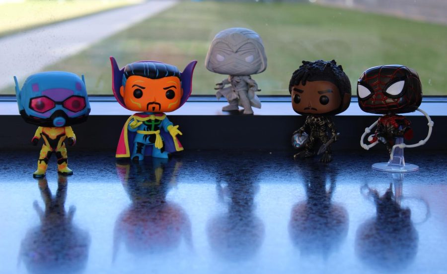 A bunch of Marvel Funco Pops sit on a bench at Lightridge High School