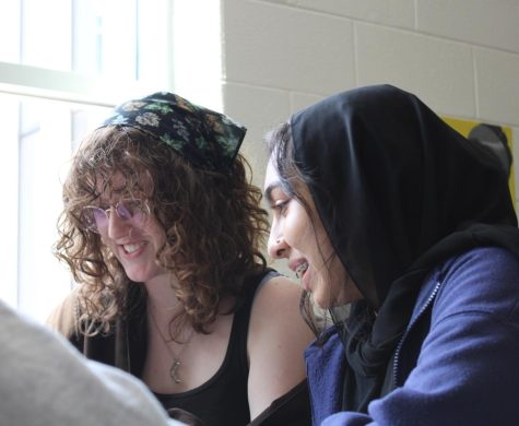 Two students study next to a window