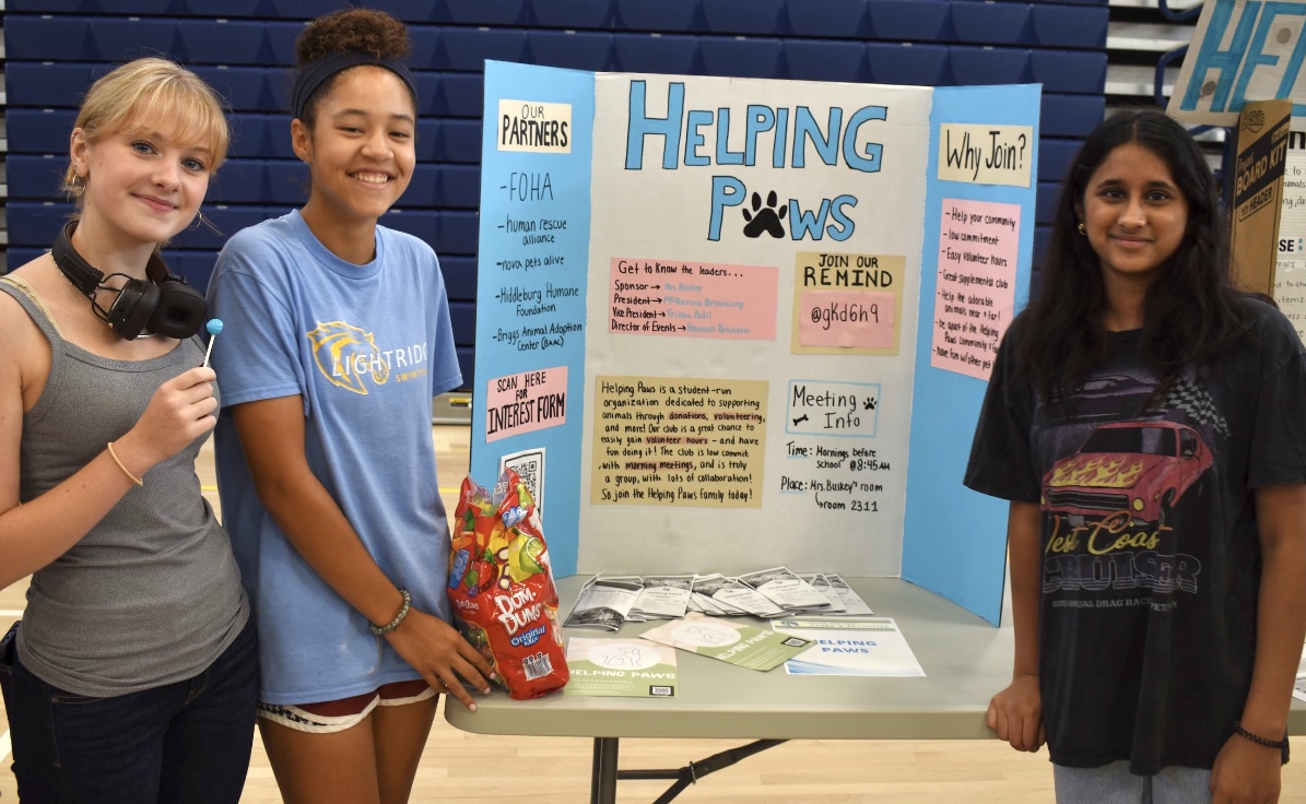 Kelly Walsh, Hannah Branson and  McKenna Browning promote Helping Paws by giving candy to anyone who’s interested in their club.