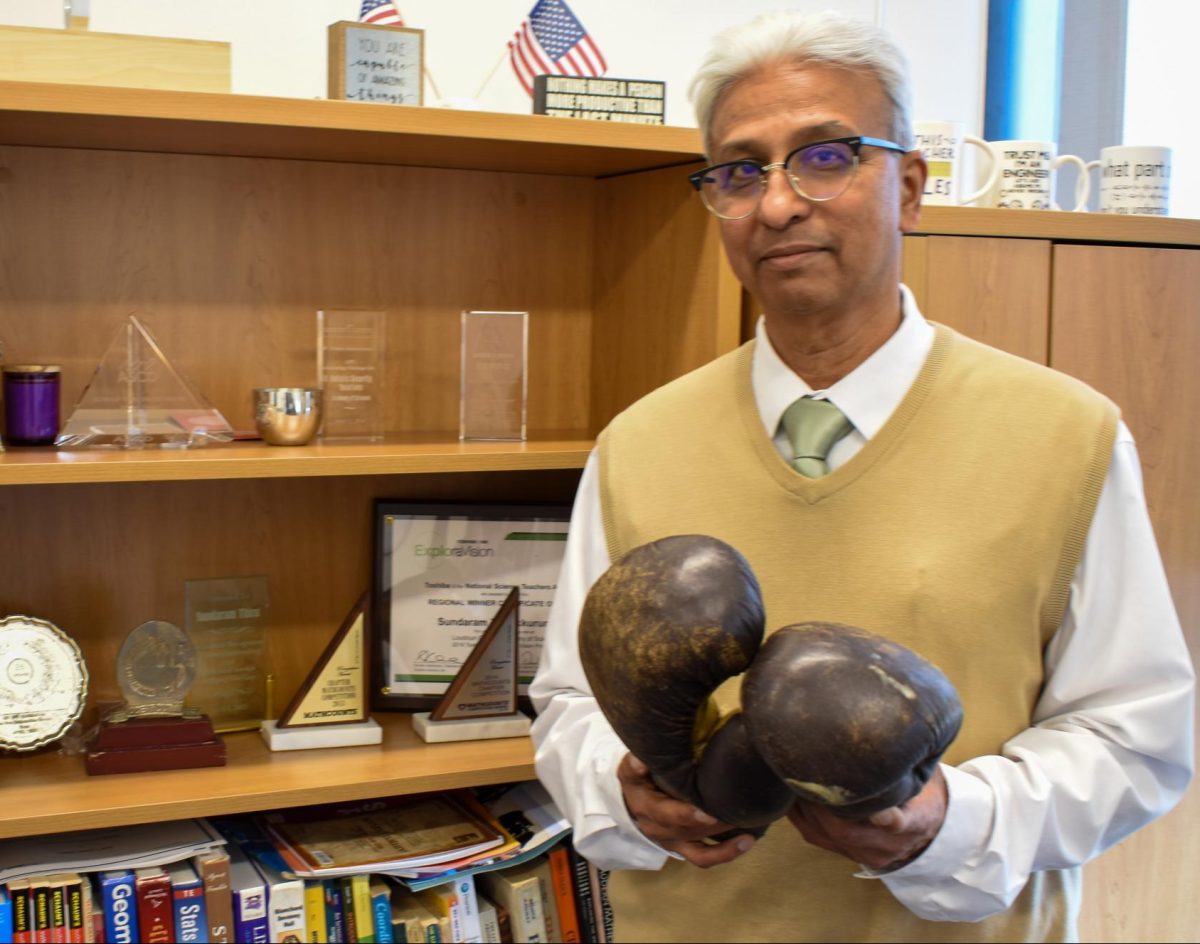 Assistant Principal Sundaram Thirukkurungudi shows off  his many awards and some souvenirs  from his boxing career.