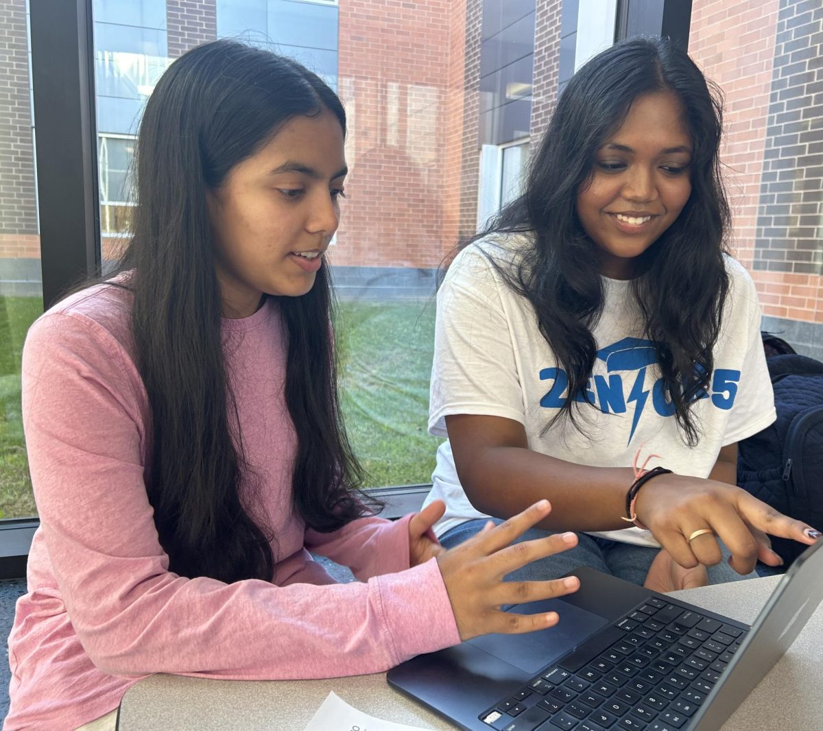 Writing center tutor, junior Lalitha Aravind, assists senior Riya Jayshankar with her college essay.