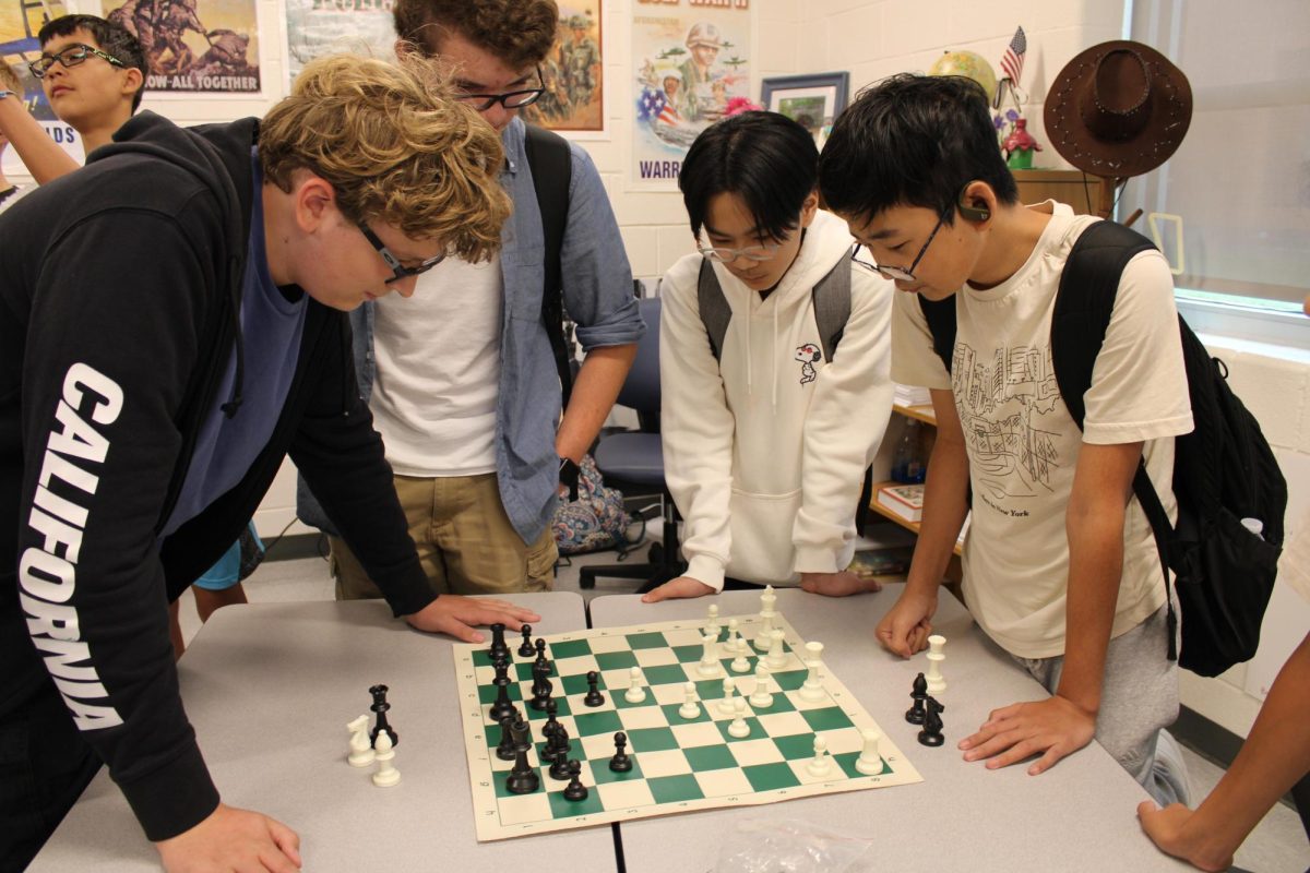 Members of the chess club survey the board during the preliminary club meeting day.  Photo courtesy of Lightridge Yearbook.