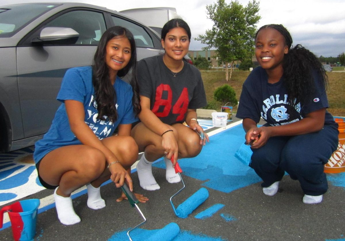 Lightridge News staff members Kailani Marantan and Jessica Abuya flank Ashika Datla as all three work on Abuya's spot.