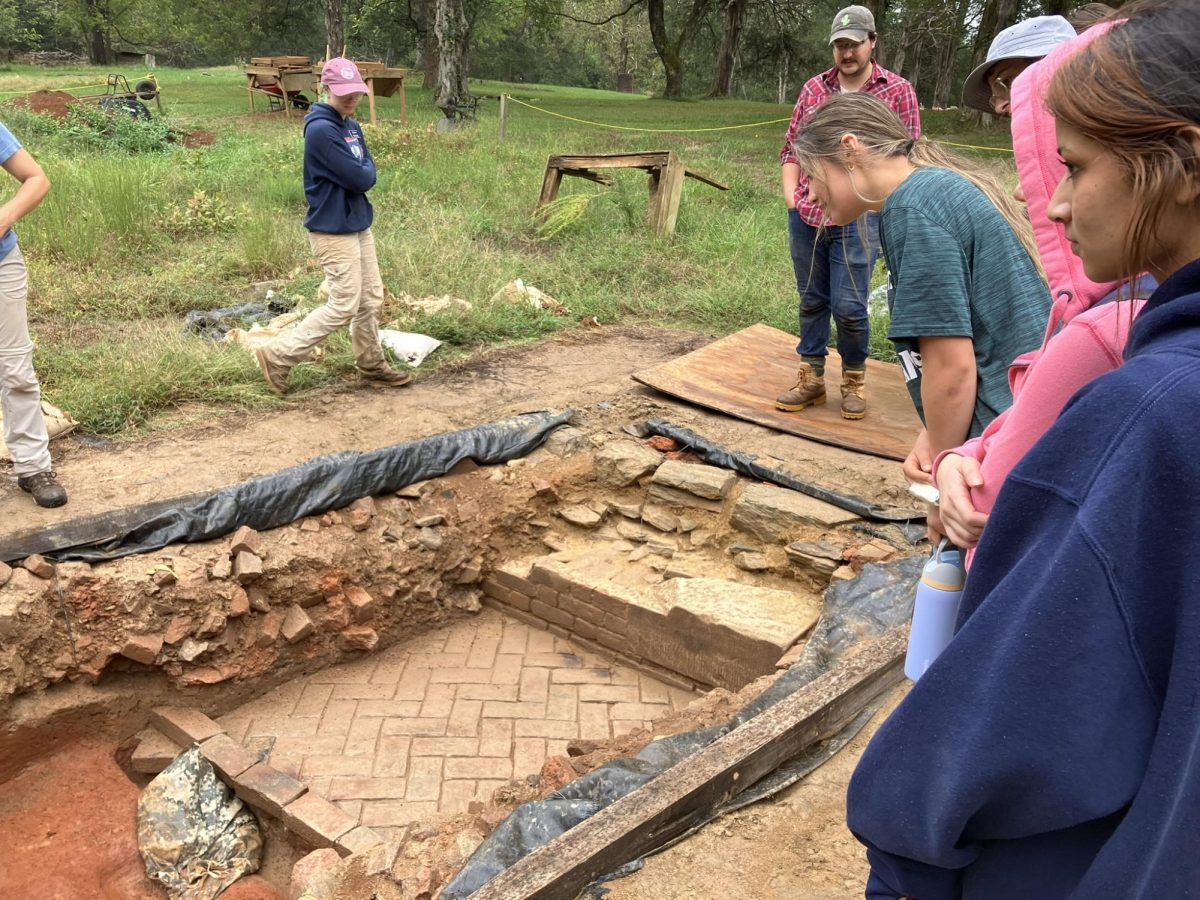 Seniors Ava Zanies and Anandita Saxena (foreground) examine a dig site at Historic Germanna.  Photograph provided by Christopher Johnson. 